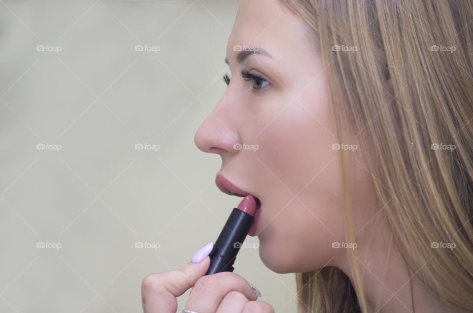 woman paints her lips