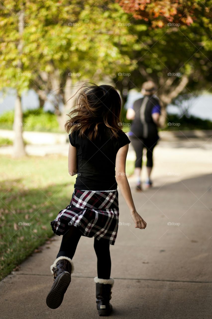 Girl running in the park and an old lady jogging