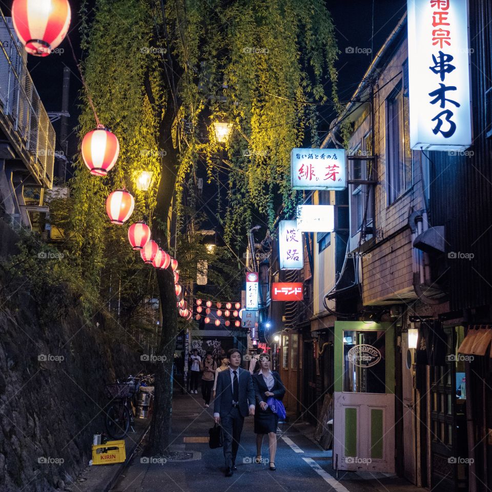 Lanterns and signs light up a charming little street in Tokyo, Japan.