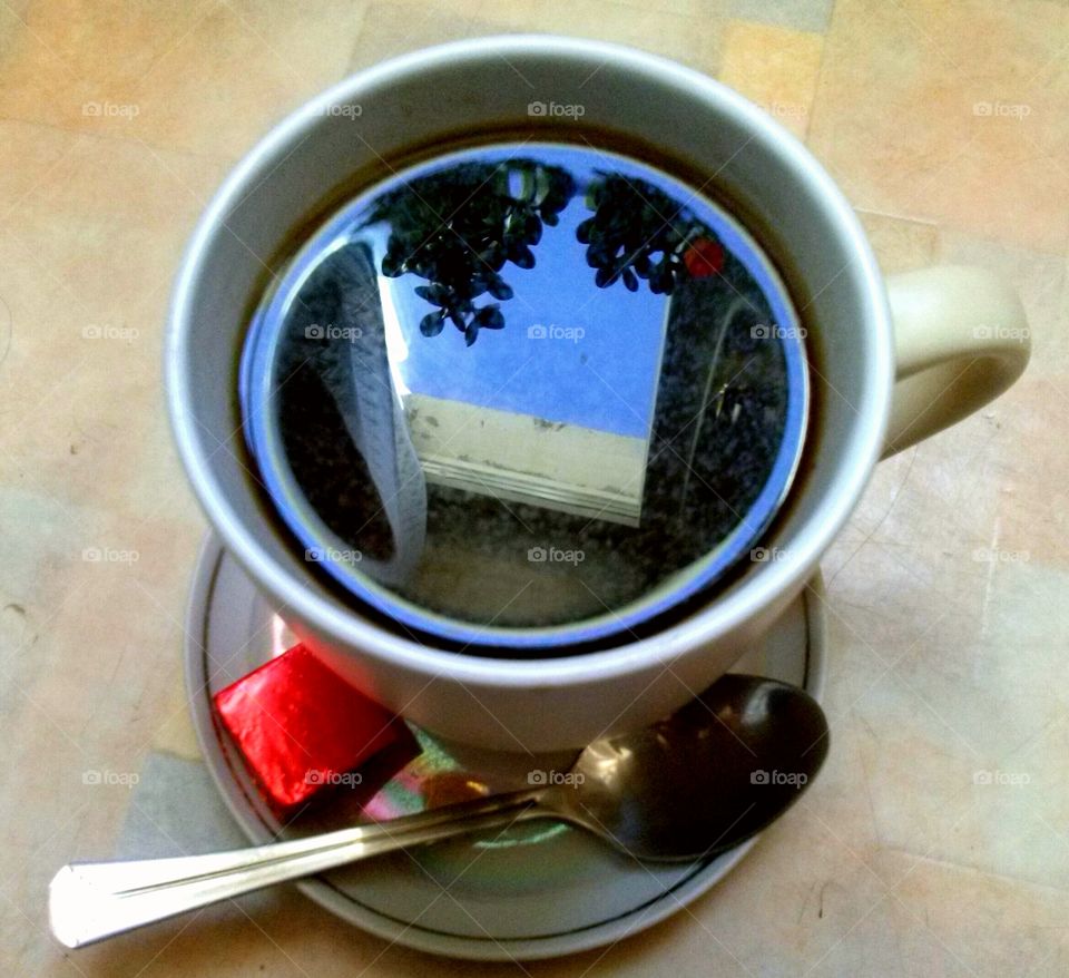 red chocolate, cup of coffee with reflection of blue sky