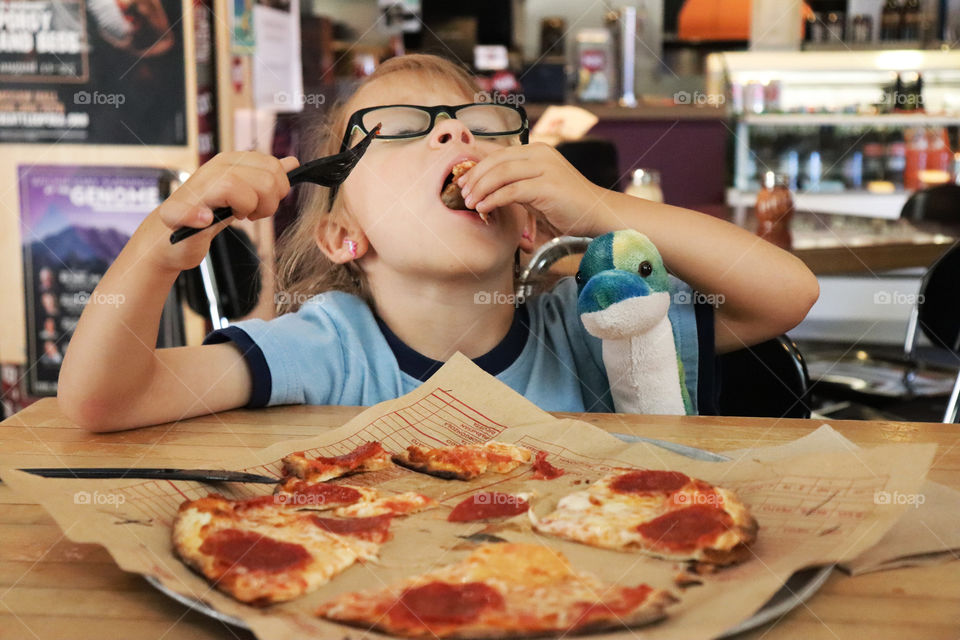 Child loves to eat pizza