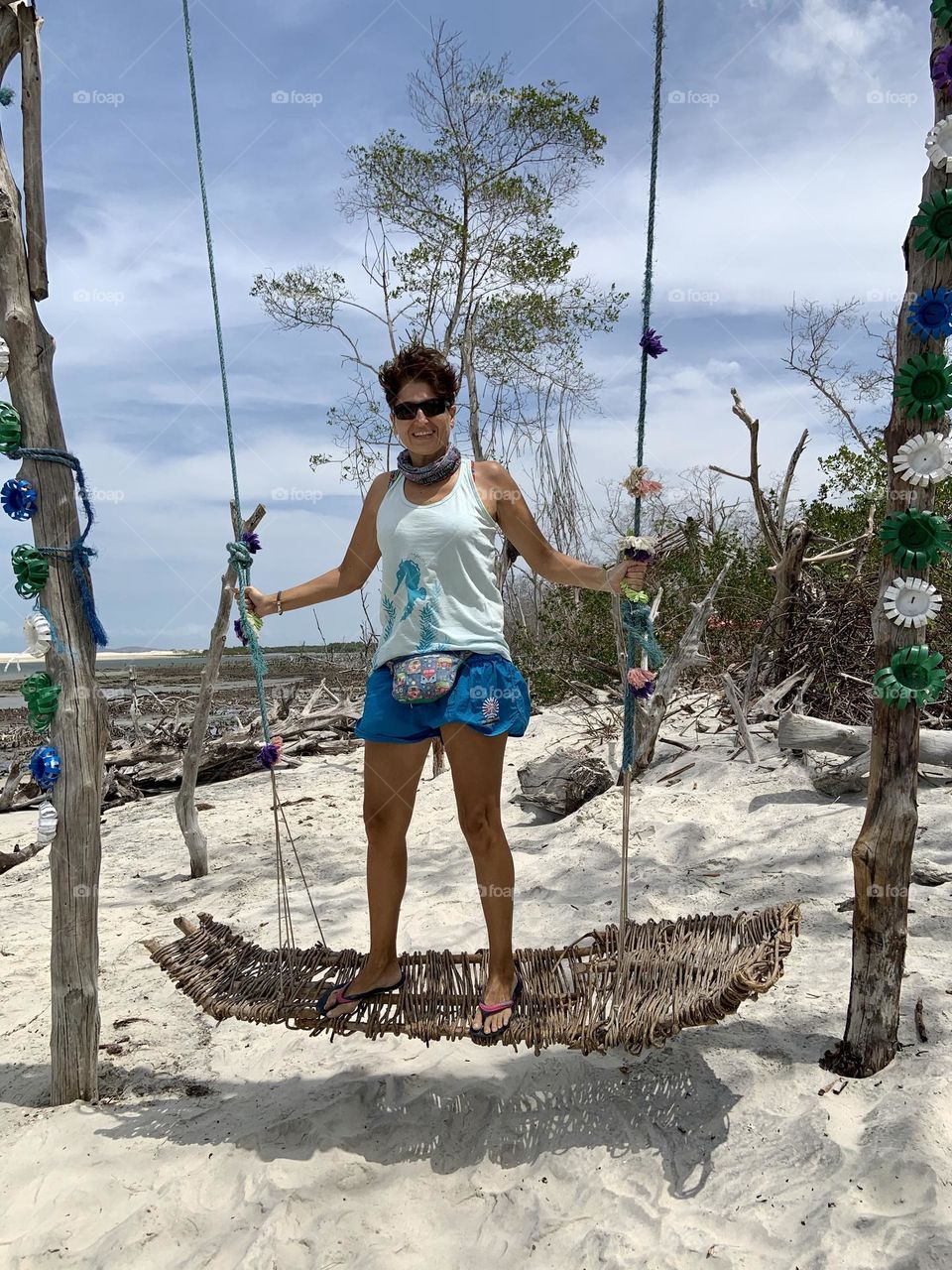 Woman swinging in the desert beach 