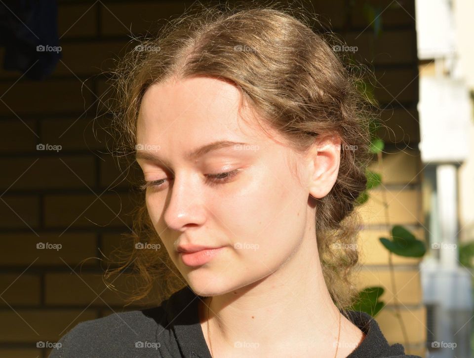 girl beautiful portrait in sunlight on a brick wall background, natural beauty woman