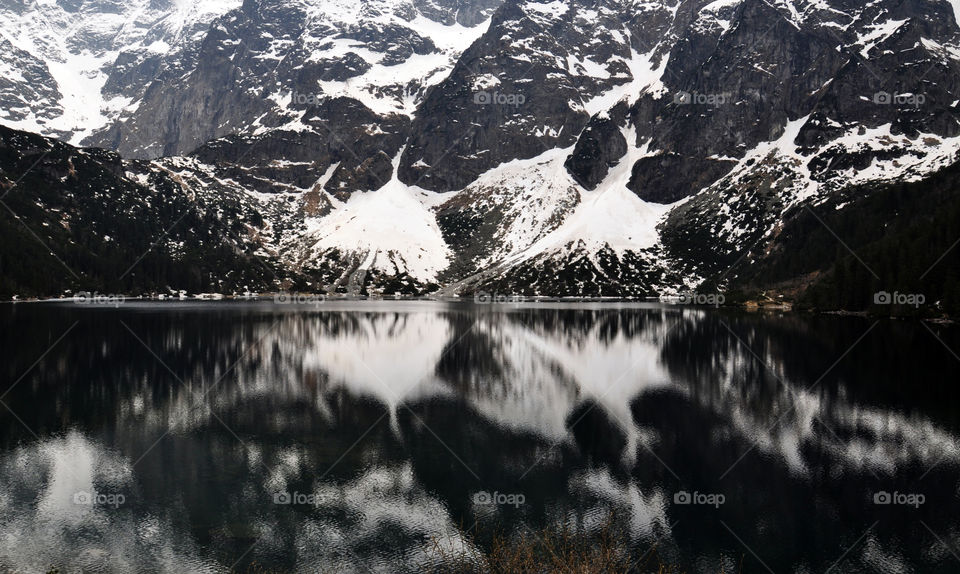 Snowy mountain reflecting on lake