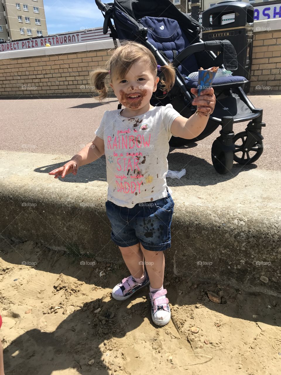 Little girl enjoying a chocolate ice cream on a hot day