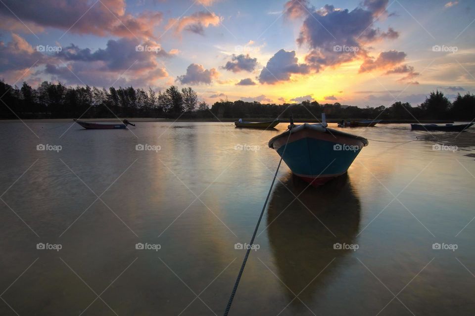 scenic boat in water with sunset
