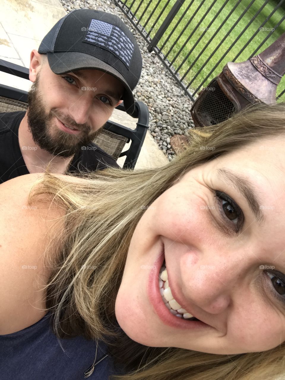 Selfie time with the husband; wife sitting on husbands lap during barbecue