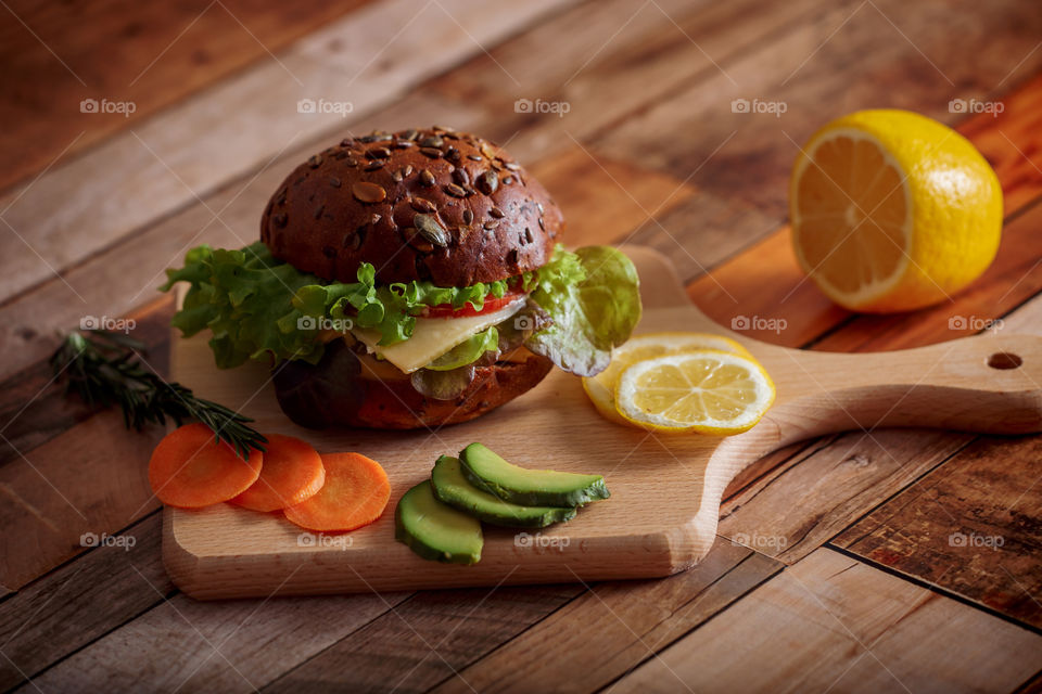 Dark burger with grain bread, cream cheese and avocado