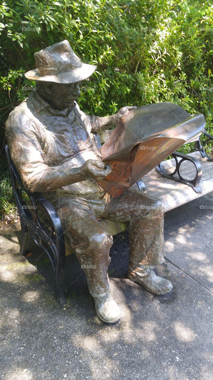 Sculpture at Brookgreen Gardens in South Carolina of an old man reading a newspaper