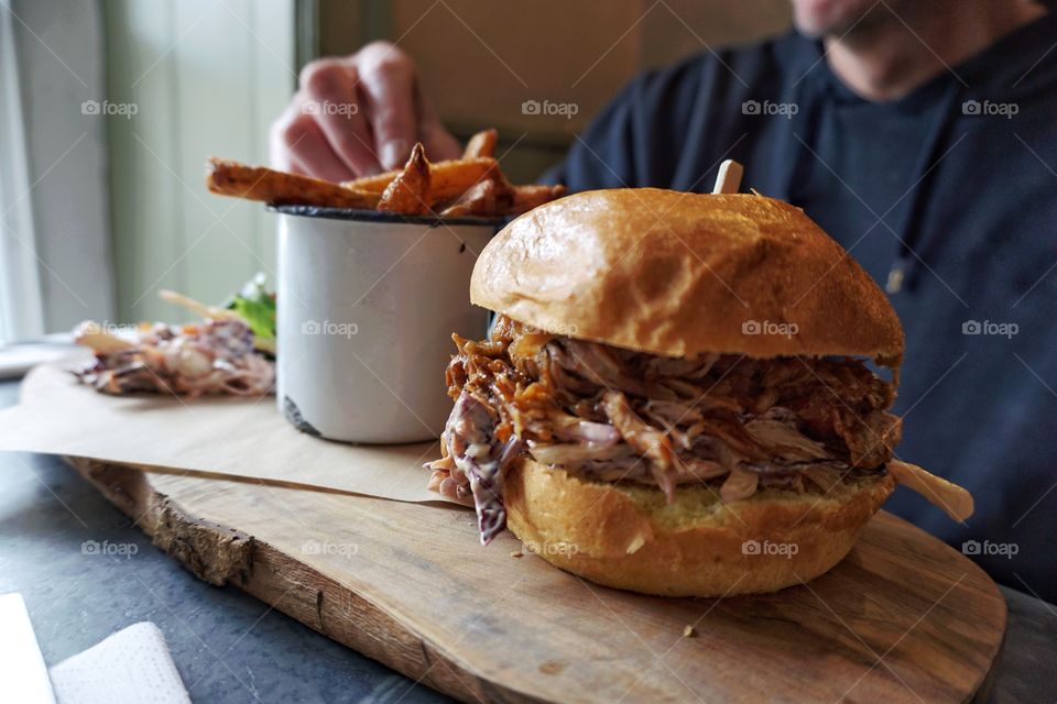 Huge pulled pork bun and a mug full of triple cooked chips 