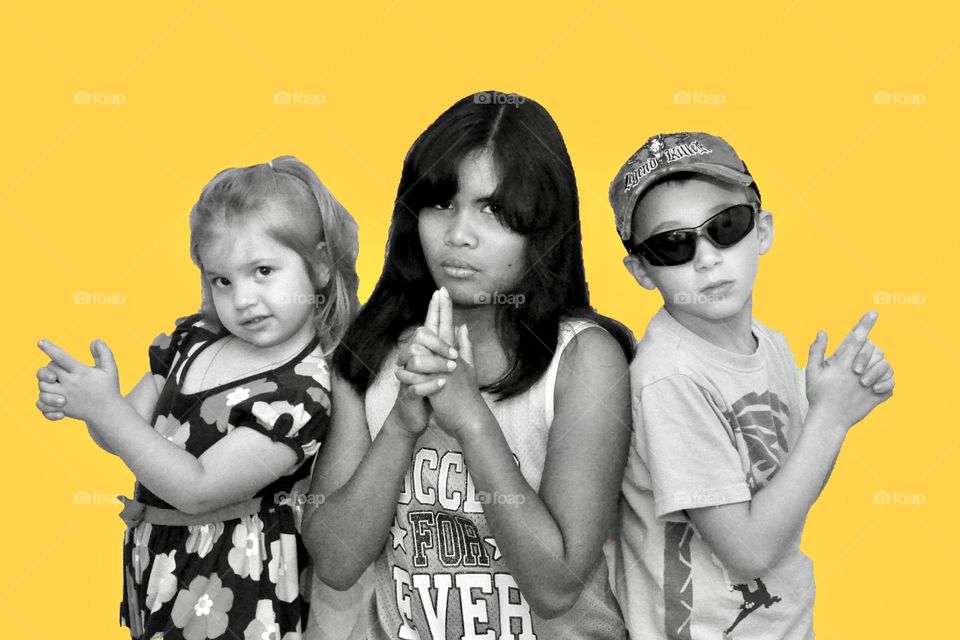 Three children posing like Charlie’s Angels 