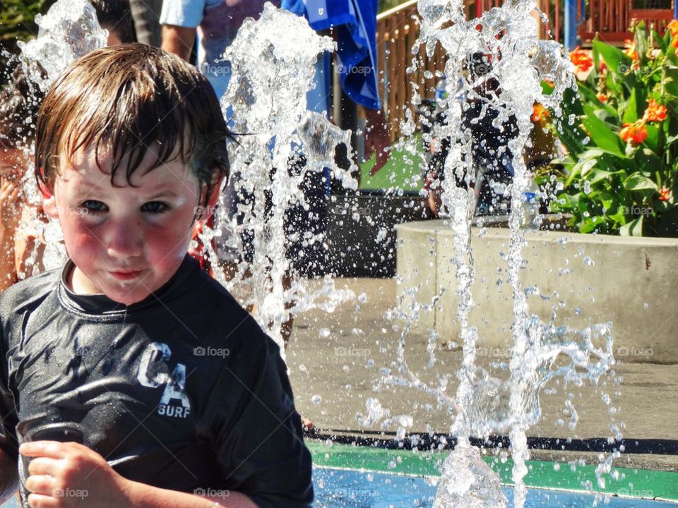 Boy In A Water Fountain. Summertime Fun
