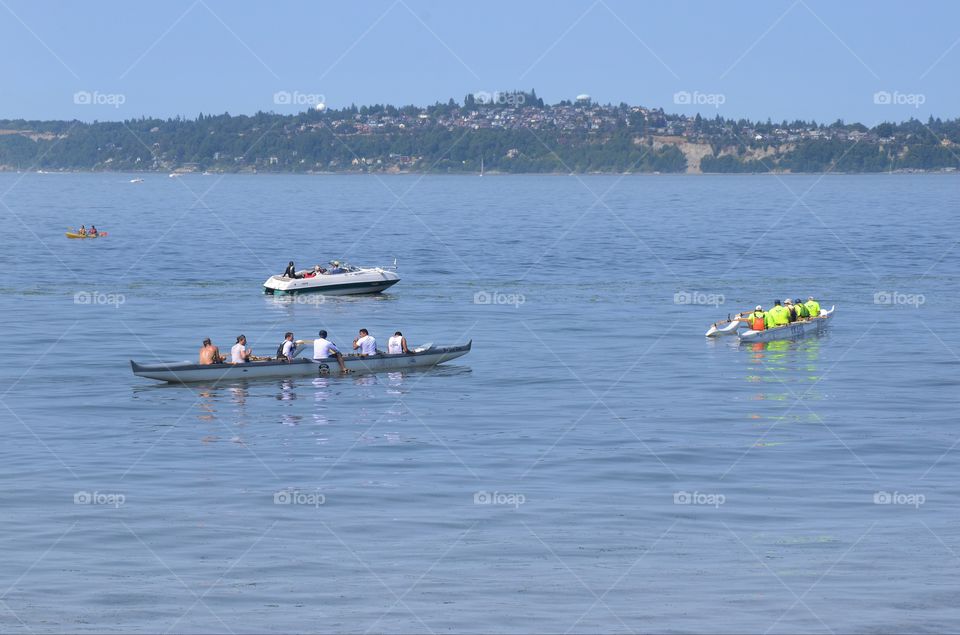 Kayakers paddle as a  team in a kayaking competition in the Puget sound of West Seattle, Washington.