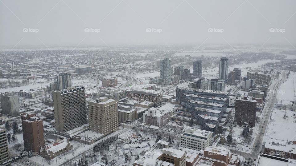 View from up high of snow covered downtown city of Calgary, Alberta, Canada. Buildings and streets, landscape in wintertime.