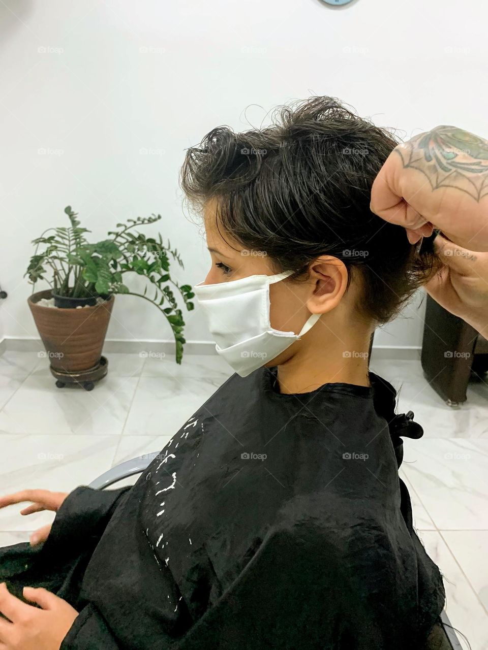 Hairdresser cutting girl's hair
