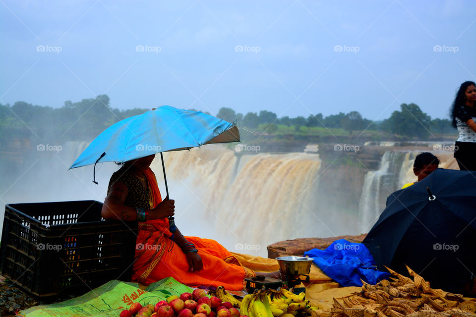 women sitting near waterfall