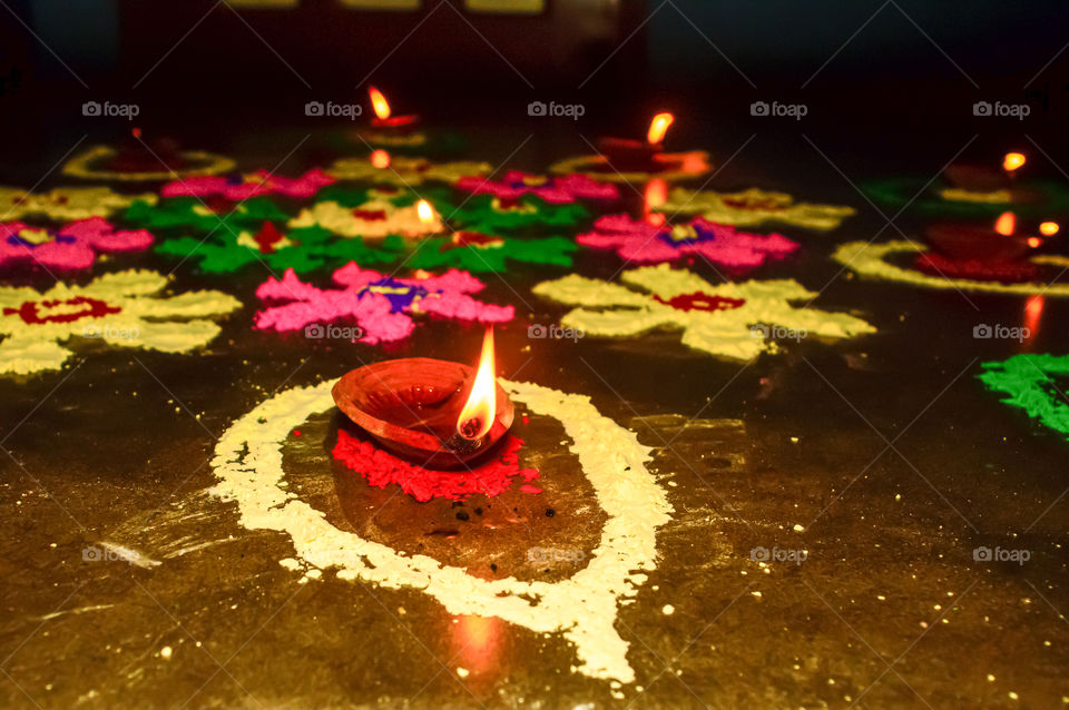 Diya Oil lamp in Rangoli decoration in Diwali festival. Concept of removing darkness.