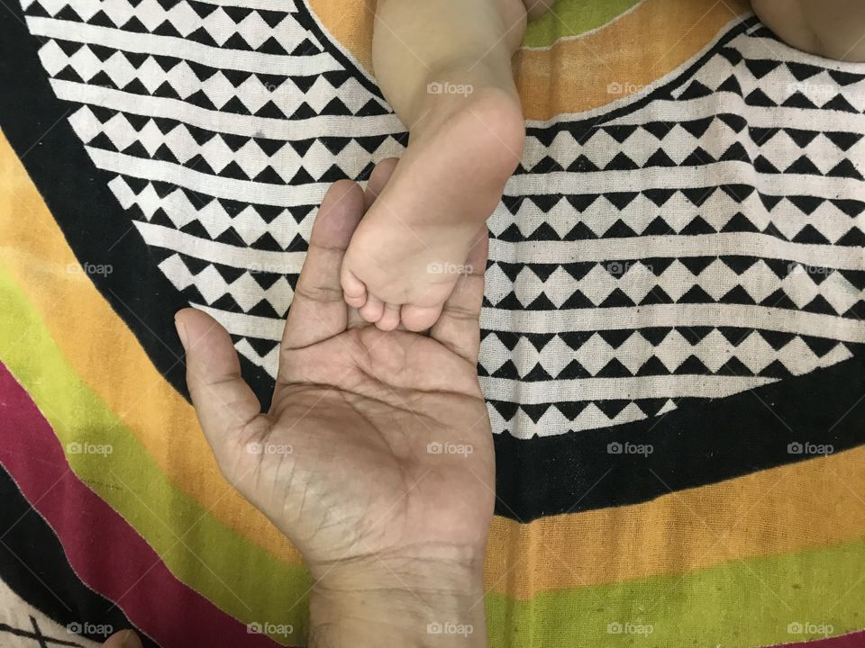 Child's feet on the palm of a father