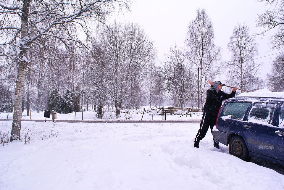 Taking off the snow from the car roof