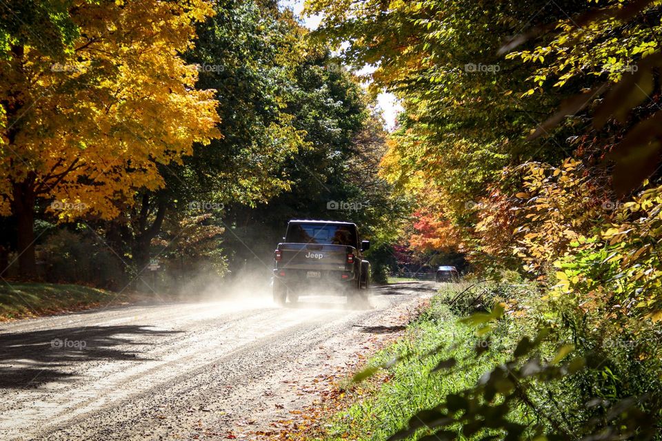 Jeep on a dusty road during a gorgeous autumn days