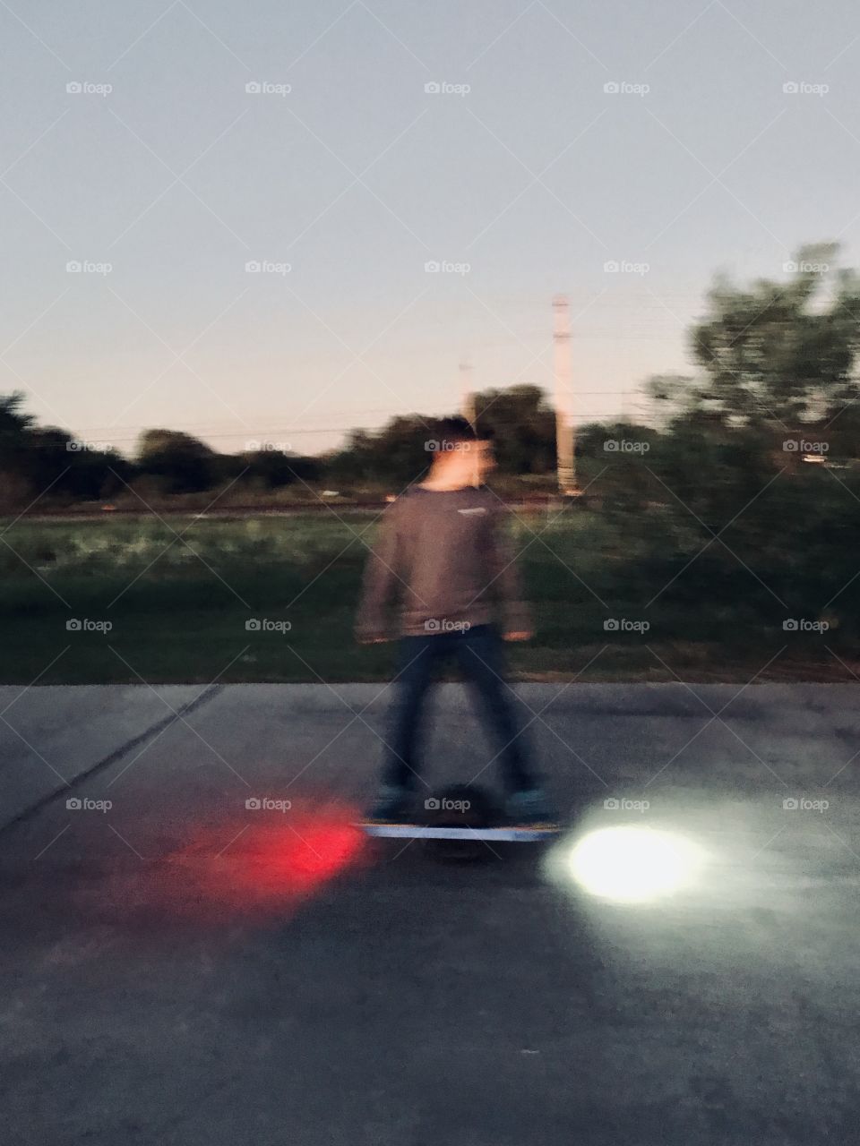 I was walking to my Sunset Lake when this person riding a electric skateboard with headlights and tail lights which is very out of the normal. I snapped this Pic. 