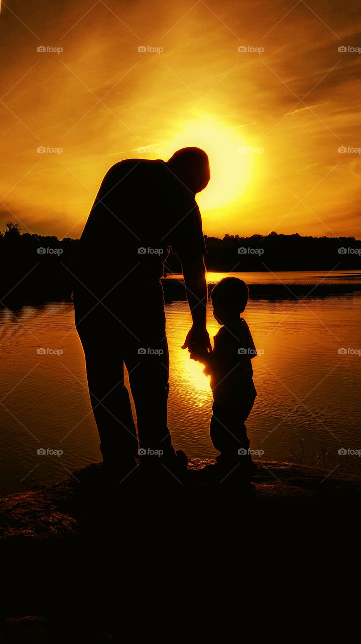 Father Son. saw a boy and his father throwing rocks in a lake. asked to take their photo.