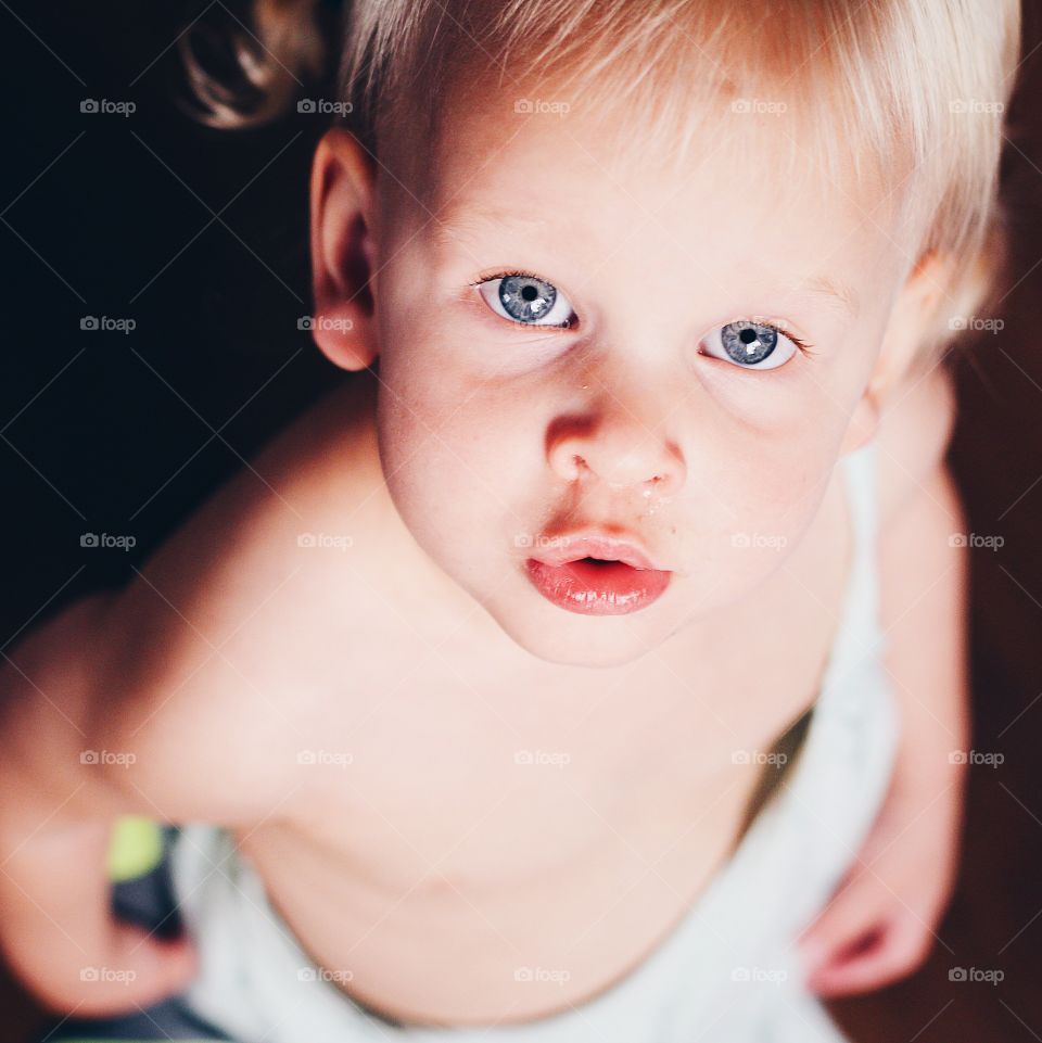 Dramatic picture of baby girl with beautiful blue eyes and blond hair