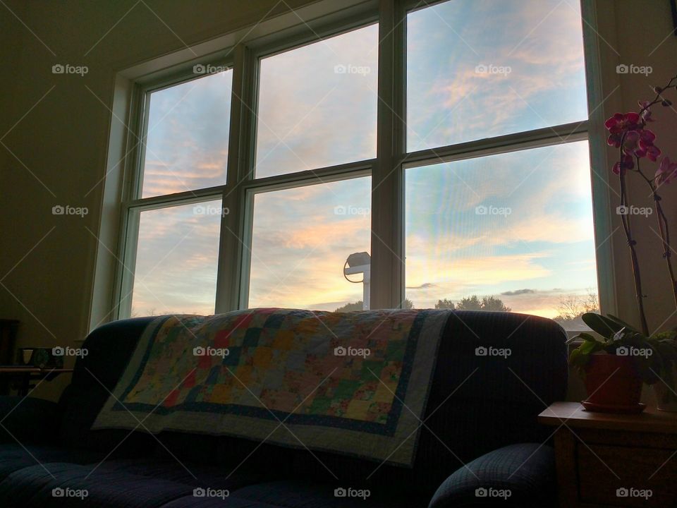 colorful sunrise seen through a living room window