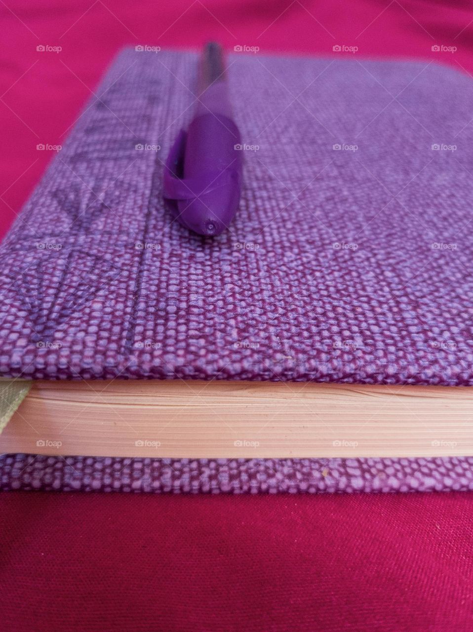 purple diary, purple pen on purple diary, pink background