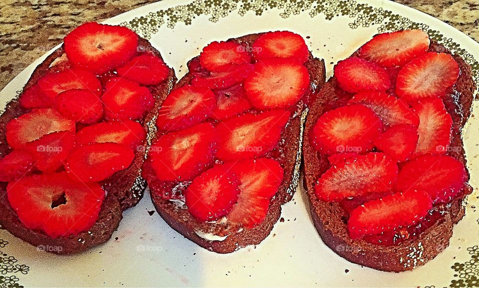 Fresh sliced strawberries on pumpernickel toast with strawberry preserves. Top with strawberry yogurt,optional.