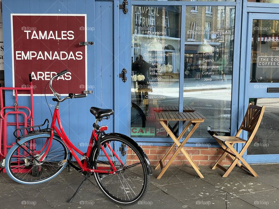 One lonely bicycle parked outside a cafe 