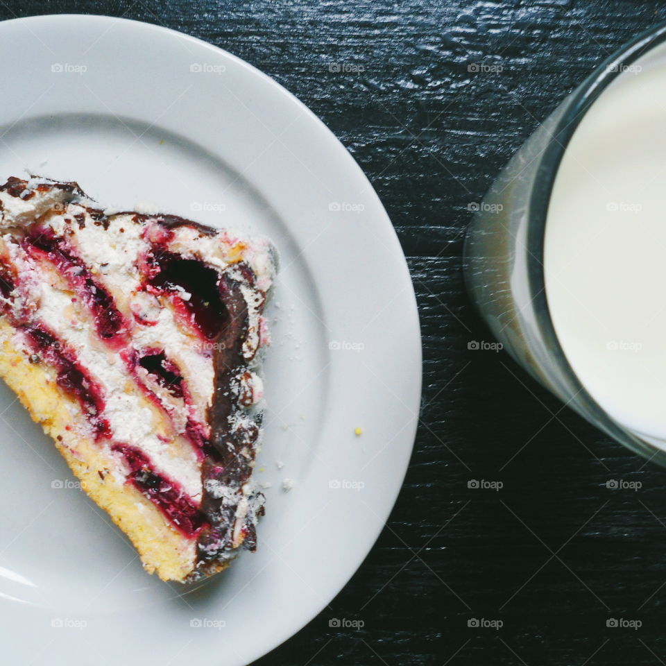 a cake with cherries and chocolate, and a cup of milk