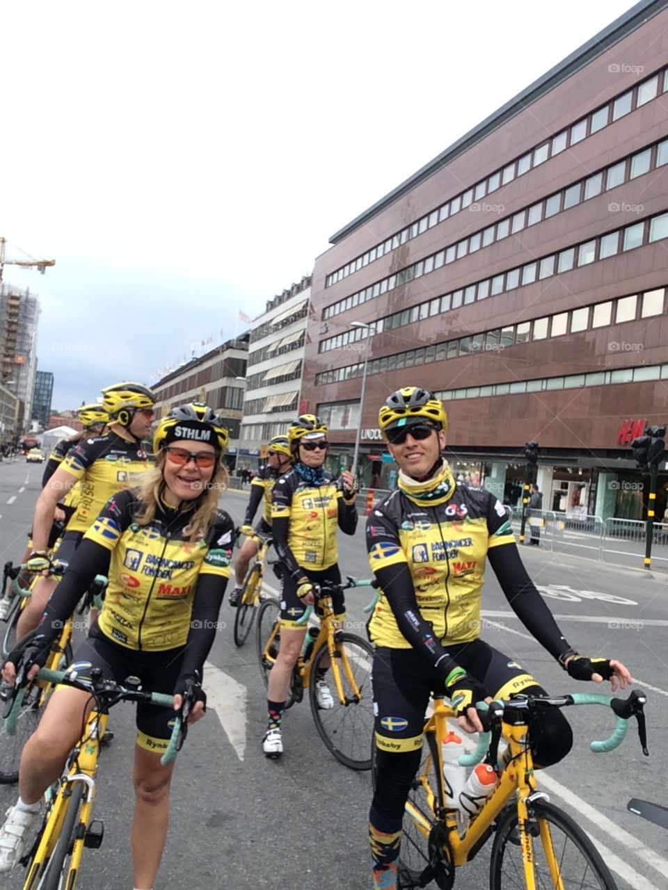 Team of cyclists in yellow clothes in stockholm city