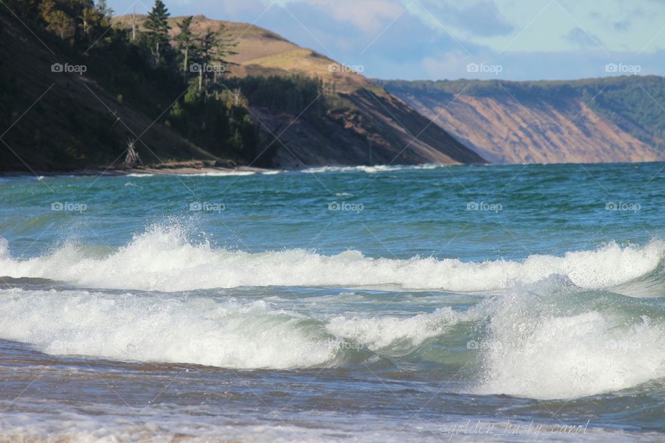 waves crashing and splashing on Lake Superior on a beautiful partly sunny, cloudy day in the upper peninsula of Michigan