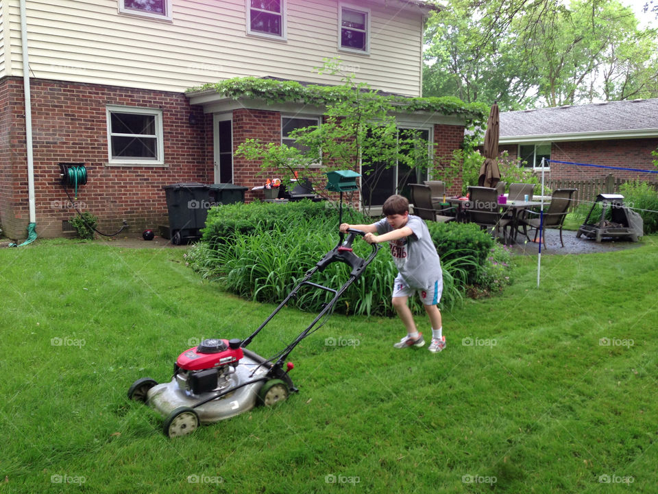 Kid mowing lawn