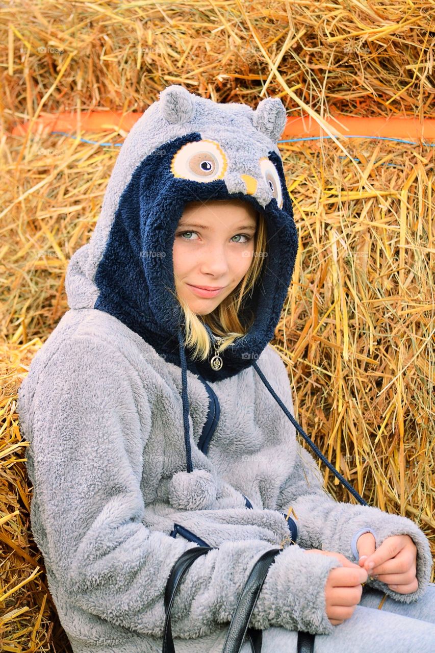 Girl sitting among straw