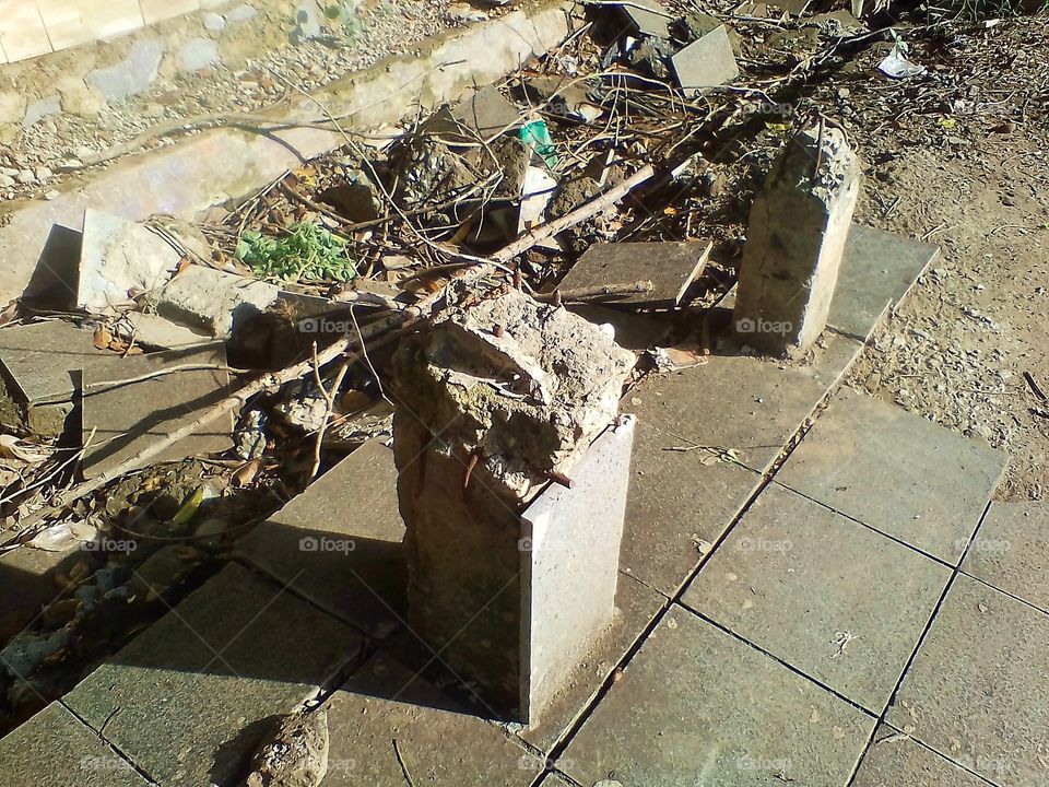 Pieces of old buildings that have been damaged are on the edge of the road in the park