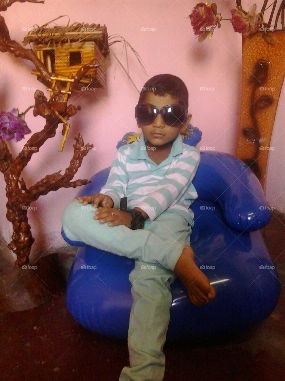 A boy sitting  a toy seat