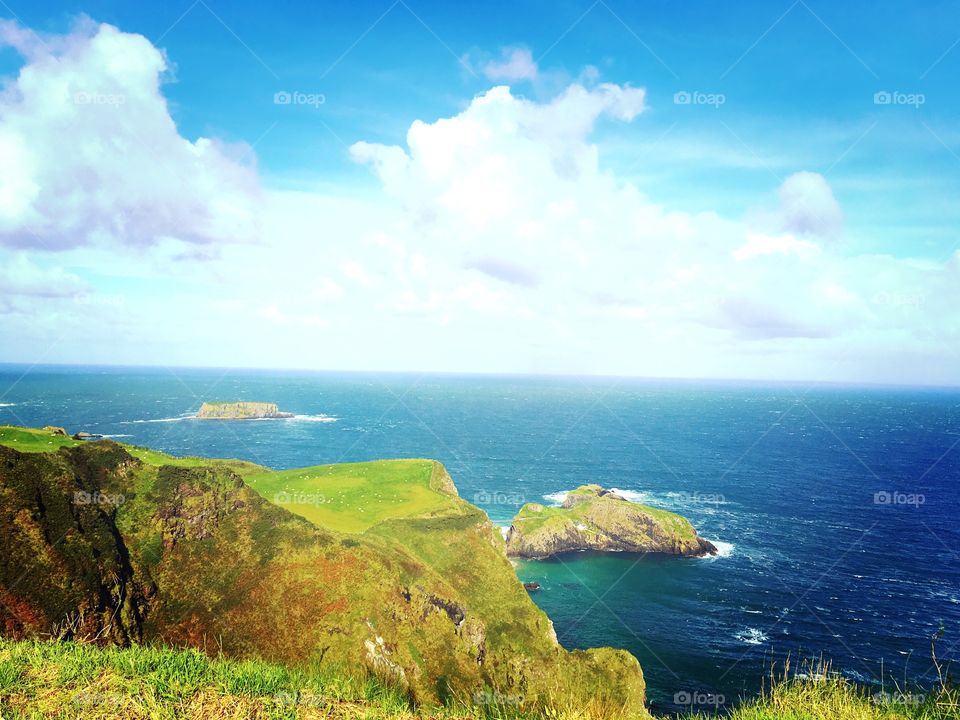A beautiful view of Northern Ireland’s grassy cliffs and blue ocean 