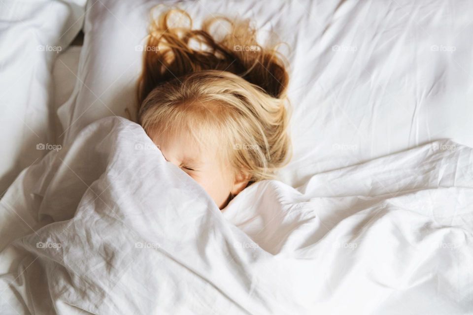 Cute kid having fun in bed