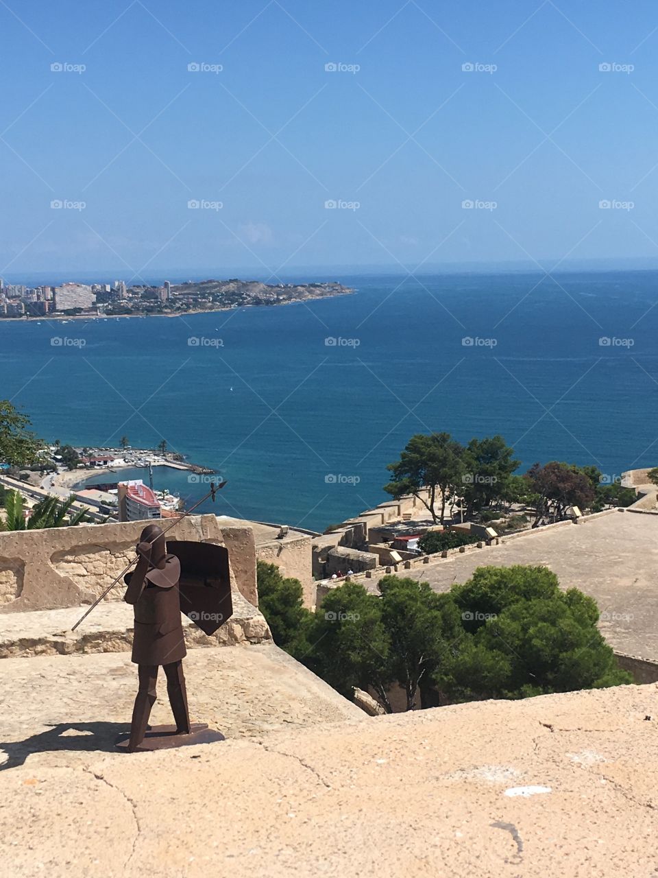 A picture taken of the view from Santa Barbara Castle in Alicante, Spain. Includes an ancient metal sculpture of a warrior 