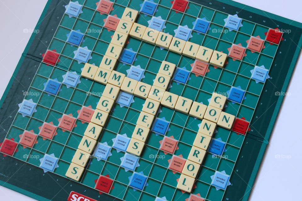 Scrabble board spelling out words about immigration issues