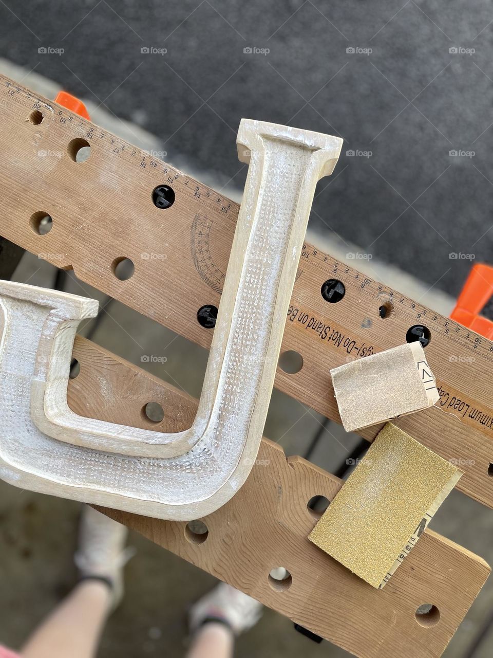 Sanding a letter, working on a letter J, making a present, workspace in the garage 