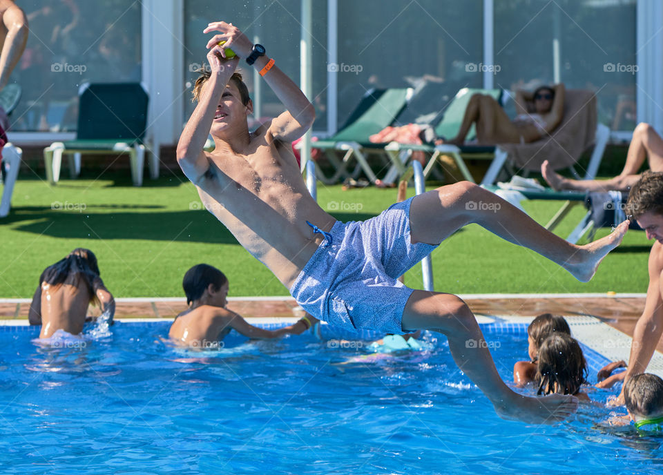 Shirtless man jumping in swimming pool