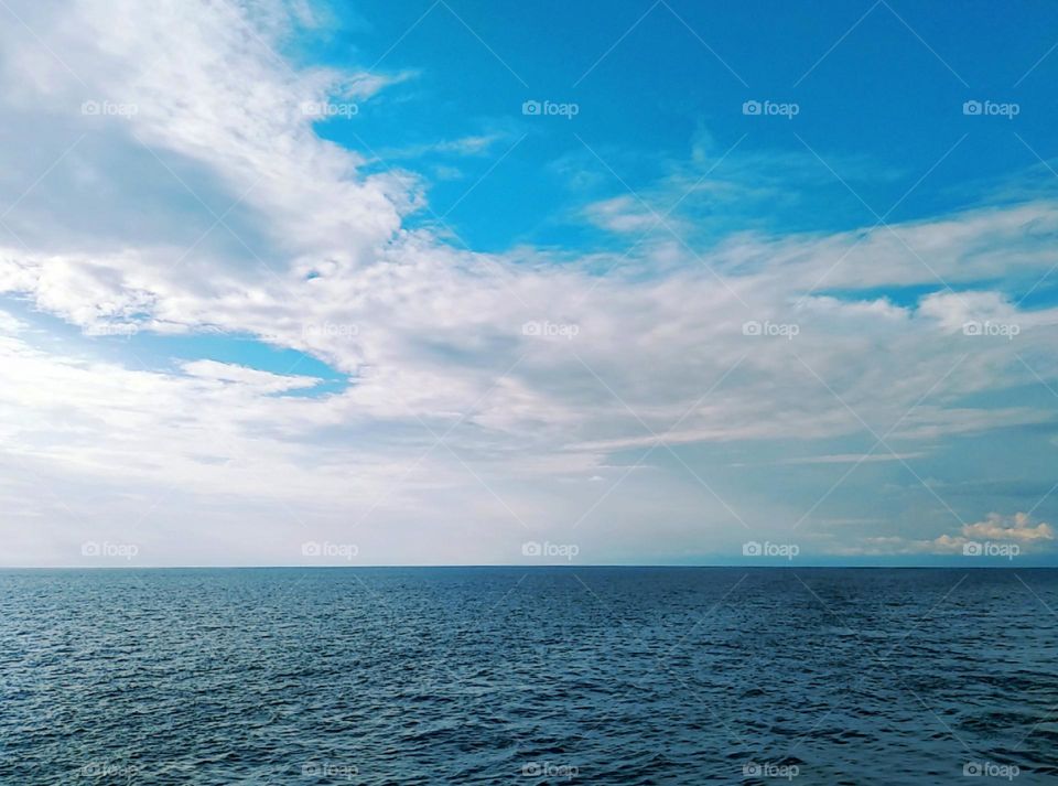 Cloudscape on the sea, the big cumulonimbus in the blue sky.