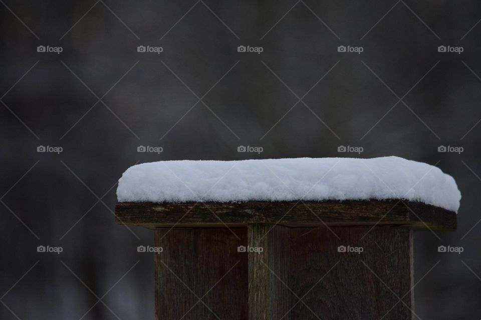 snow on a wooden seat 