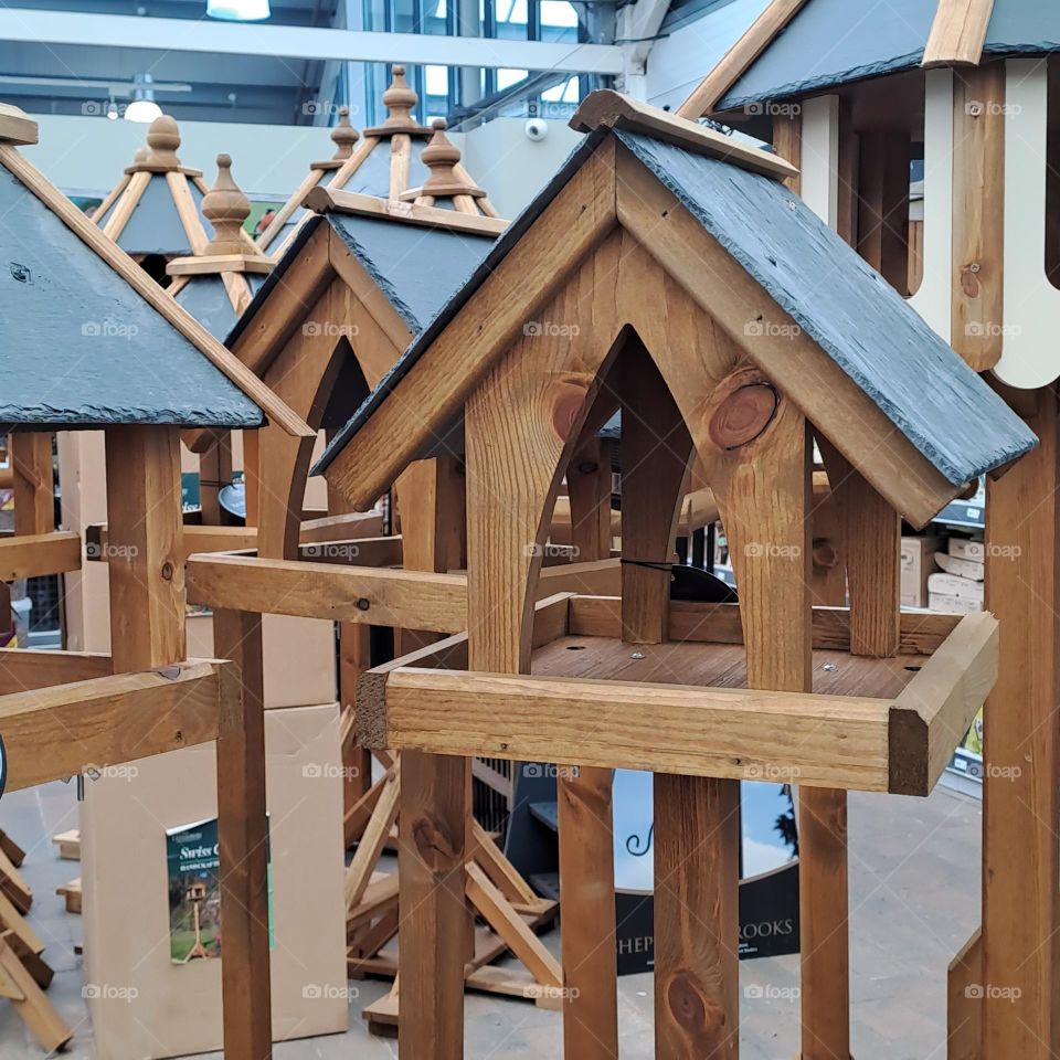 many bird houses on stands together in a shop to sell