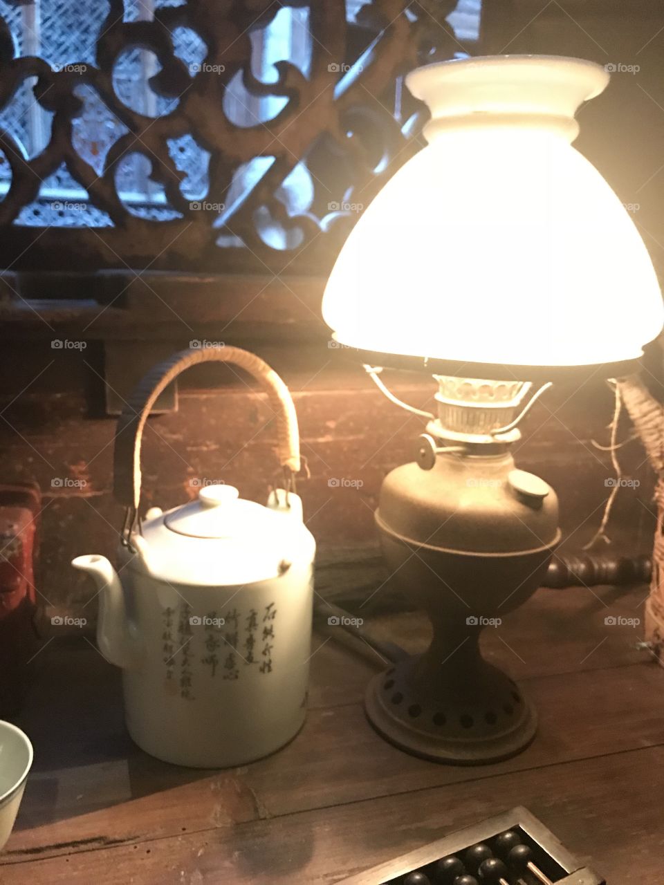 A Chinese table set up with a lantern and teapot