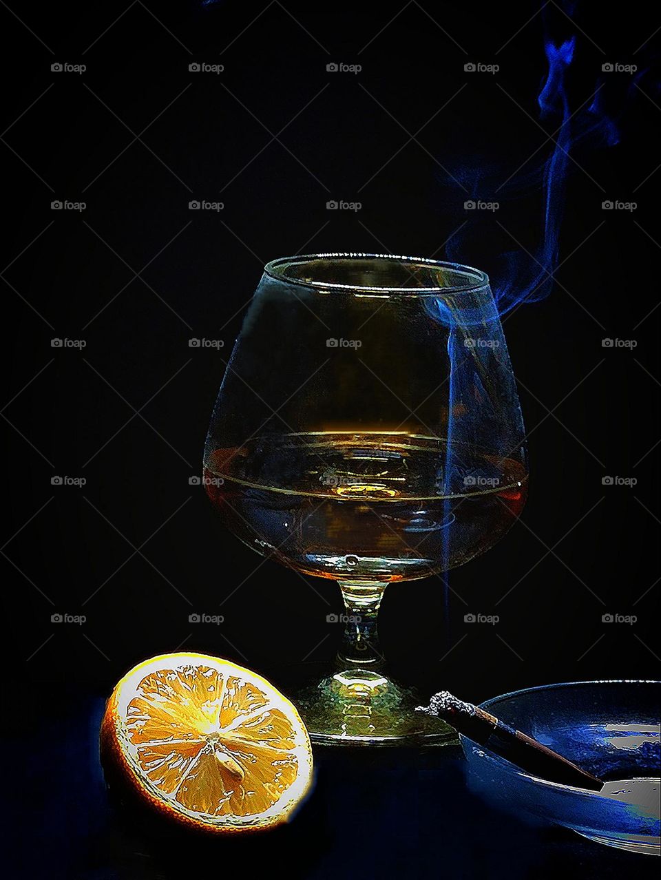 A glass of cognac, half a lemon and a half-smoked cigarette with smoke coming out of it. Black background