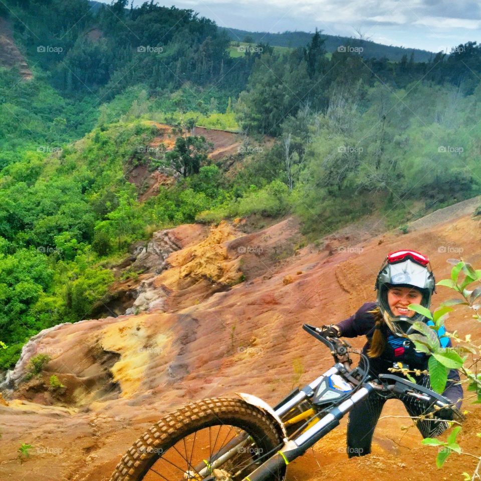 Pushing dirtbike up a cliff 